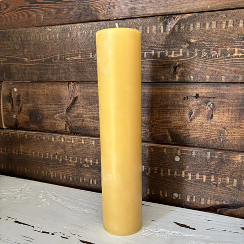 Yellow candle on a wooden surface with a rustic background