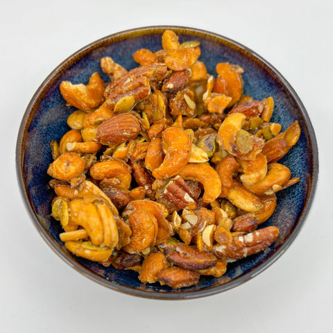  Finished hot honey mixed nuts in blue bowl on white background