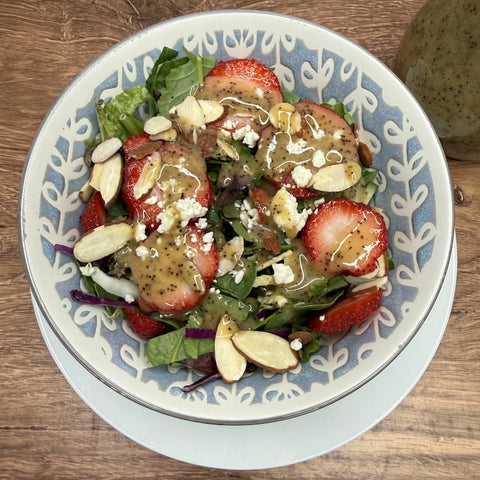 salad with dressing in bowl on wooden surface
