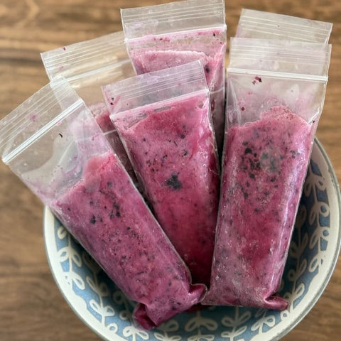 Bowl filled with baggies of purple freeze pops