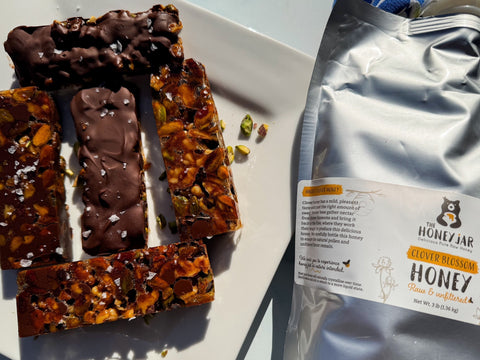 Chocolate Honey Nut Bars on white plate next to container of clover honey