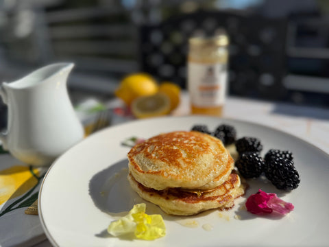 Pancakes and Berries on white plate in front of blurred background
