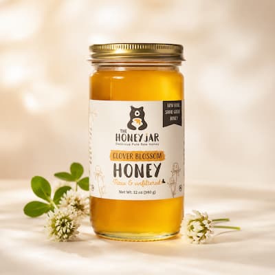 Jar of clover honey with a The Honey Jar label on a light background