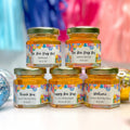 Five jars of honey with personalized labels on a colorful background
