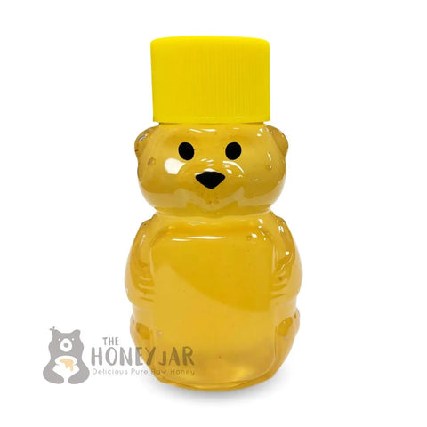 2 oz honey bear shown with yellow lid and filled with honey.