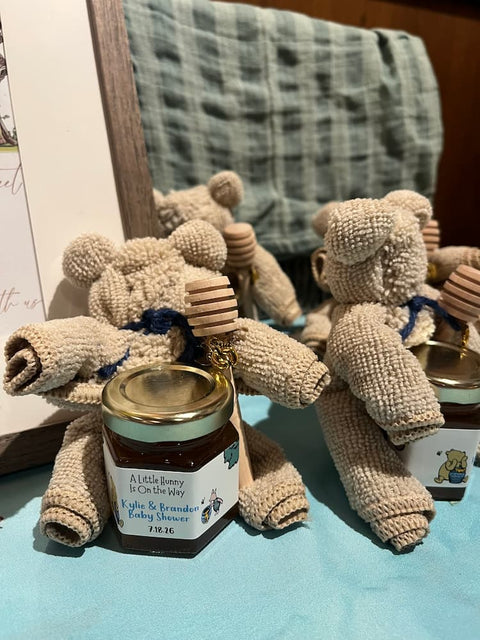 Jars of honey with labels and honey dippers with bear-shaped towels