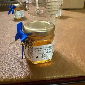Jar of honey with a blue bow on a textured surface