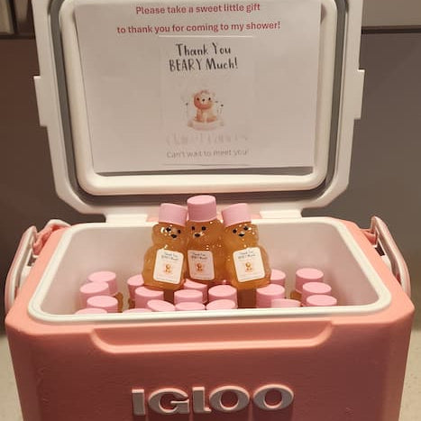 Pink Igloo cooler with teddy bear-themed bottles inside, on a countertop.