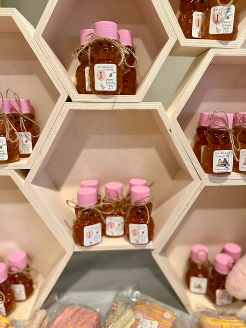 Honey bears with pink lids on honeycomb shaped shelf