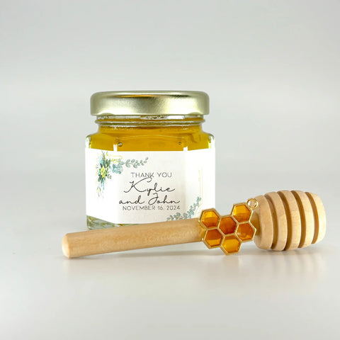 2 oz hexagon jar filled with honey, gold lid, 3" wooden honey dipper, enamel honeycomb charm, and personalized eucalyptus design on label with title Thank You.