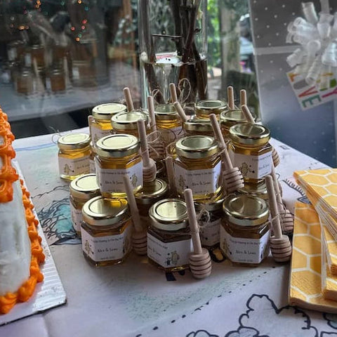Stack of honey jars with honey dippers on patterned surface