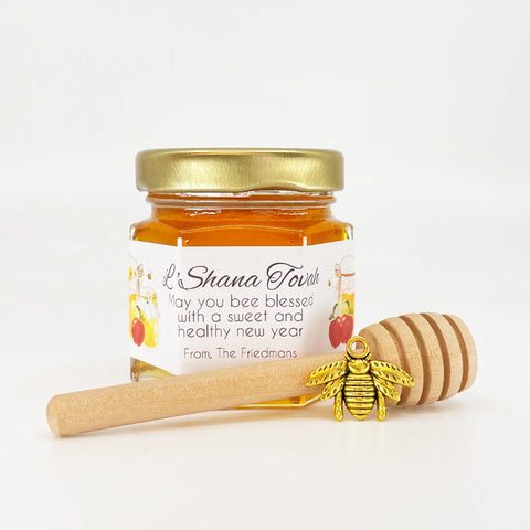 2 oz honey jar favor with gold lid, 3" wooden honey dipper, gold bee charm, and personalized honey and apples design on label with L'Shana Tovah as the title.