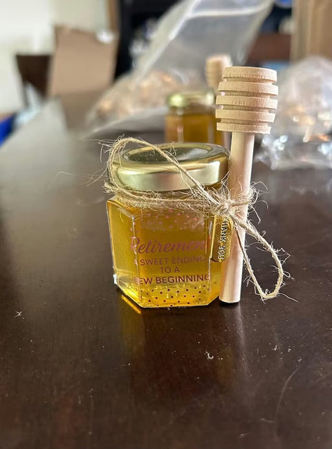 Small jar of honey with a wooden dipper on a table