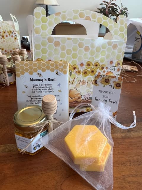 Bee-themed set with honey jar, soap, and decorative packaging on a wooden surface.