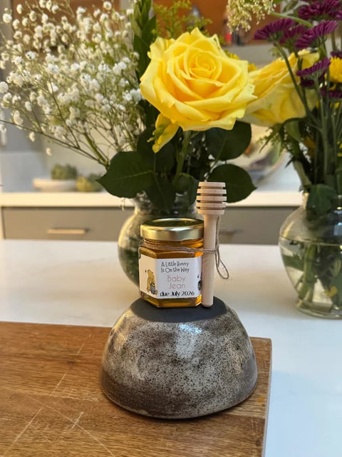  Jar of honey with label and gold lid on stand with yellow rose