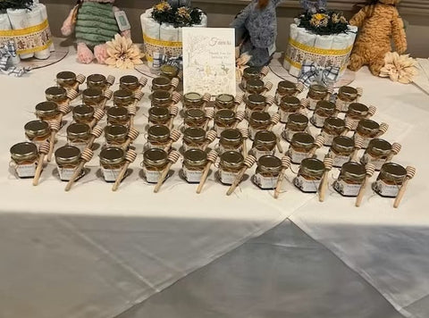 Table with honey jars and a sign at a baby shower.