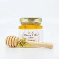 2 oz honey baby shower favor in hexagon jar with 3" honey dipper, gold bee charm, gold lid, and personalized rose laurel label. Label title is Mommy to Bee.