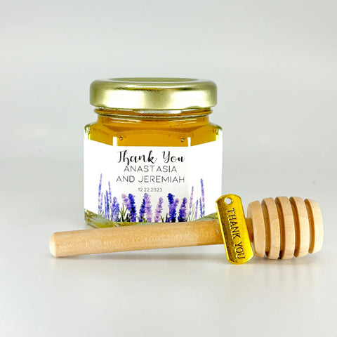 2 oz hexagon honey favor filled with honey. Jar has gold lid, 3" wooden honey dipper, gold Thank You charm, and personalized lavender design on label with title Thank You.