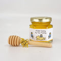 2 oz hexagon jar filled with honey, gold lid, gold bee charm, 3" wooden honey dipper and Winnie the Pooh label design with hunny pots and yellow stripes and title that says A Little Yummy For Your Tummy.