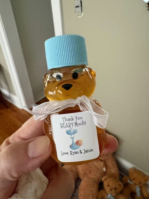 Honey bear bottle with a blue cap held by a hand, surrounded by teddy bears.