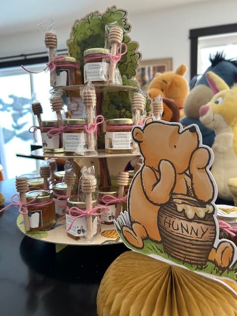 Decorative setup with Winnie the Pooh and honey jars on a stand.