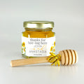 2 oz hexagon jar filled with honey, gold lid, 3" wooden honey dipper, gold bee charm, and personalized sunflower design on label with title Thanks for Bee-ing Here.