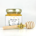 2 oz hexagon honey favor filled with honey. Jar has gold lid, 3" wooden honey dipper, gold bee charm, and personalized geometric gold frame design on label with title Thank You.