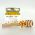 2 oz honey jar favor with gold lid, 3" wooden honey dipper, enamel honeycomb charm, and personalized wildflower design on label with Happy Rosh Hashanah as the title.