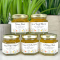 2 oz Rosh Hashanah New Year favors on hexagon jars with gold lid with personalized wildflower labels. Label titles shown are Have a Sweet New Year, Shana Tovah, Happy Rosh Hashanah, L'Shana Tovah, and To a Happy and Healthy New Year.