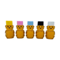 Five 2 oz honey bears shown filled with honey. Each has a different color lid: yellow, pink, blue, black, and white.