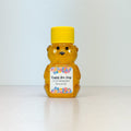 honey bear with yellow cap and personalized colorful label on neutral background