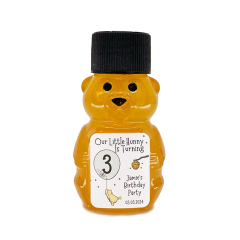 2 oz honey bear baby shower favor with black cap and personalized label. Label shows classic Winnie the Pooh with a green balloon with the title Our Little Hunny is Turning 3.