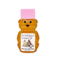 2 oz Winnie the Pooh honey bear baby shower favor with pink cap and personalized label. Label shows classic Winnie the Pooh, Piglet, and Tigger with pink party decorations with the title Our Little Hunny is Turning 2.