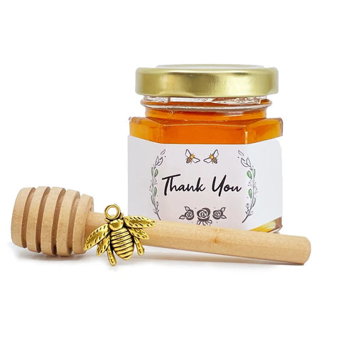 2 oz hexagon jar filled with honey, gold lid, 3" wooden honey dipper, gold bee charm, and rose laurel design on label with title Thank You.