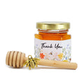 2 oz hexagon jar filled with honey, gold lid, 3" wooden honey dipper, gold bee charm, and wildflower design on label with title Thank You.