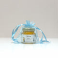 Jar of honey in a transparent blue bag on a light gray background