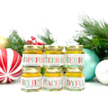 2 oz honey holiday Christmas party favor gift jars with gold lid and personalized labels. Labels feature multicolored holiday greeting titles, including Bee Hopeful, Bee Cheerful, Bee Merry, Bee Joyful, Bee Peaceful, and Believe. Christmas ornaments and garland in background.