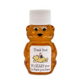 2 oz Winnie the Pooh honey bear baby shower favor with white cap and label. Label shows classic Winnie the Pooh lying on his back with Piglet sitting on his tummy. Label reads Thank You! It's beary nice to have you here.