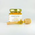 Single full set of honey wedding favors including 2 oz hexagon jar of honey, gold lid, 3" honey dipper, gold bee charm, and fall trees themed label with Meant to Bee title.