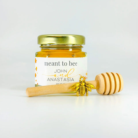 Single full set of honey wedding favors including 2 oz hexagon jar of honey, gold lid, 3" honey dipper, gold bee charm, and fall trees themed label with Meant to Bee title.