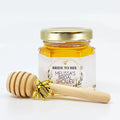 2 oz hexagon jar filled with honey, gold lid, 3" wooden honey dipper, gold bee charm, and personalized geometric design on label with title Bride to Bee.