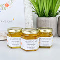 2 oz clover honey wedding favors with gold lids and wildflower personalized label. Label title is Meant to Bee.