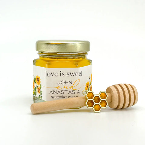 Honey favor set with gold lid, personalized sunflower field label, 3" wooden honey dipper, and enamel honeycomb charm. Label title is Love is Sweet..